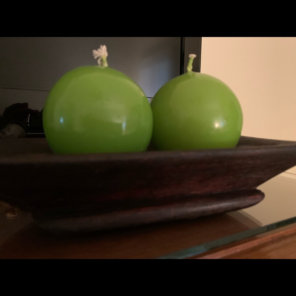 Wooden carved platter with two green candles.
